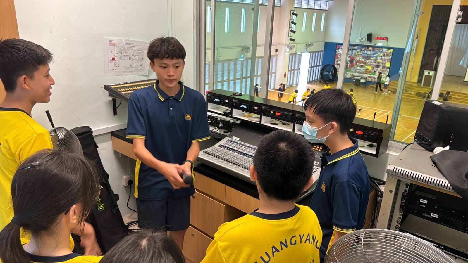Klaus explaining audio-visual equipment to fellow students in the school control room